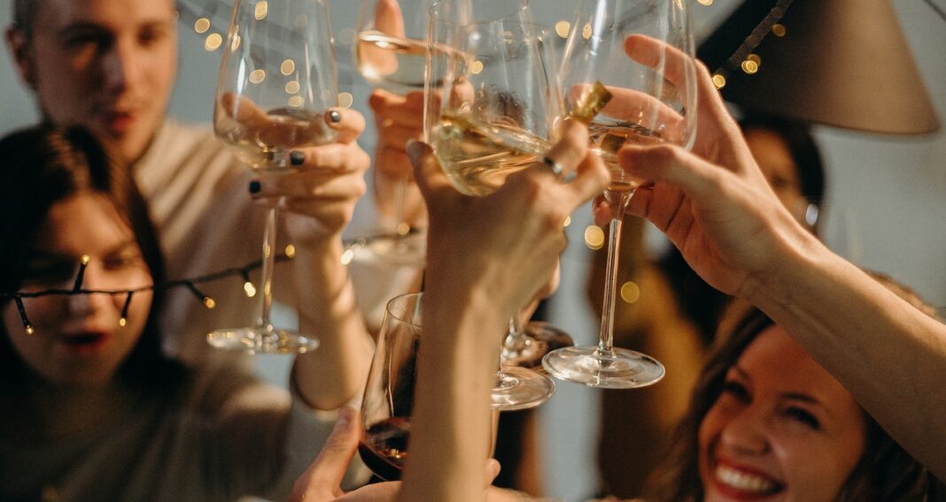 Men and women raising wine glasses in celebration.