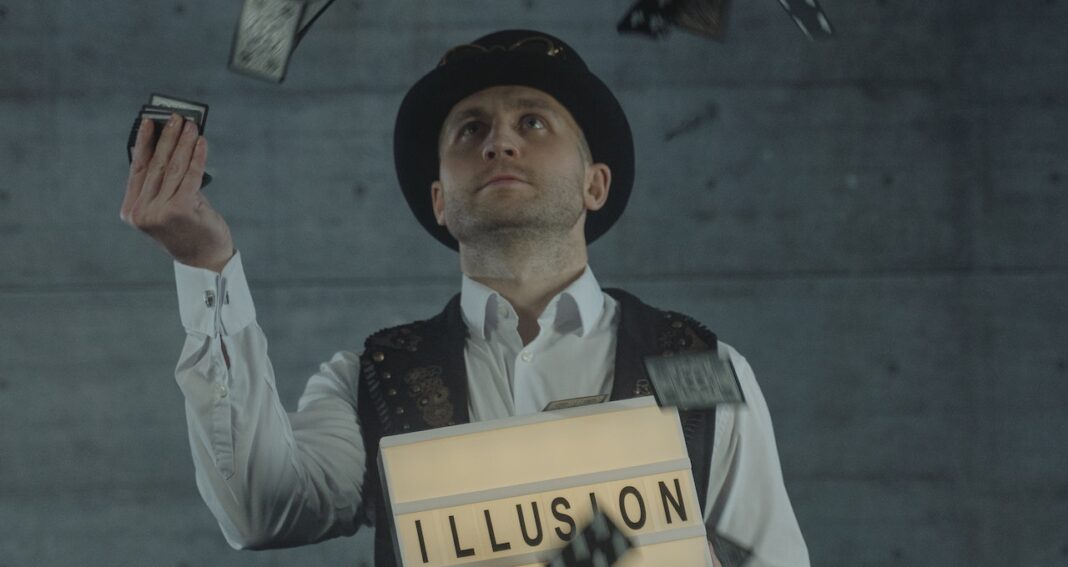 Magician juggling cards while holding a box saying illusion.