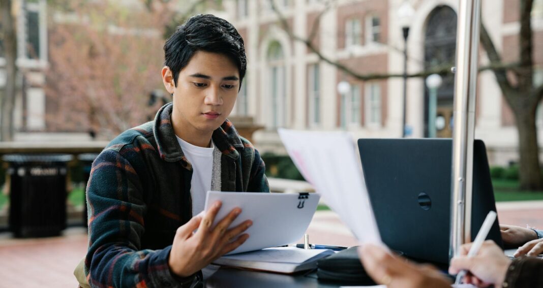 a man in plaid long sleeves reading papers
